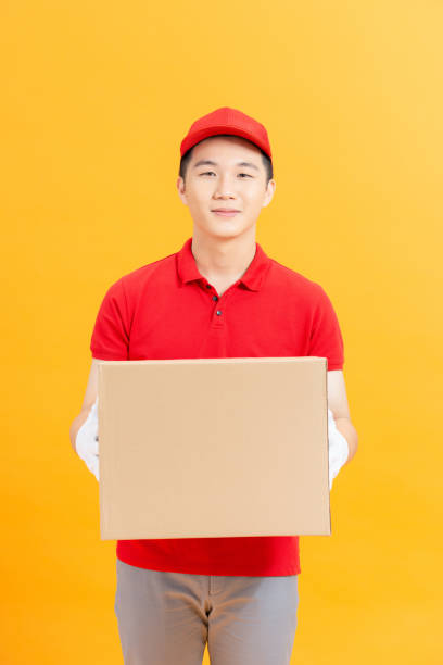 istock Smiling delivery man carrying a parcel box 1321625172