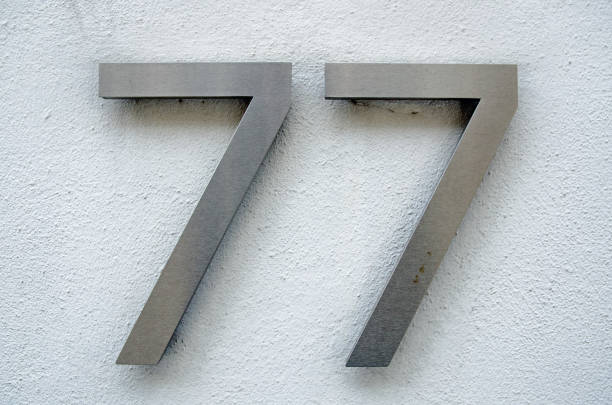 istock Brushed metal number seventy seven on a wall 1321626169