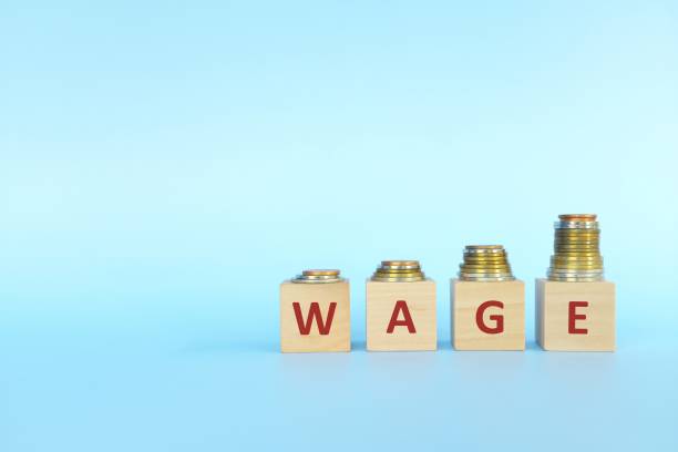 istock Salary or wage increase concept. Increasing stack of coins on wooden blocks in blue background. 1321626438