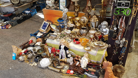 Typical merchandise at a flea market stall in Paris, France: dishware, candleholders, jewel boxes and decorative figures