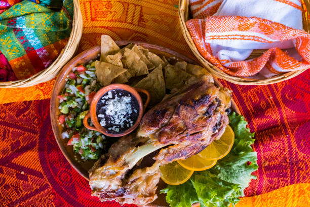 istock Roasted meat with vegetables and refried beans on colorful tablecloth 1321635246