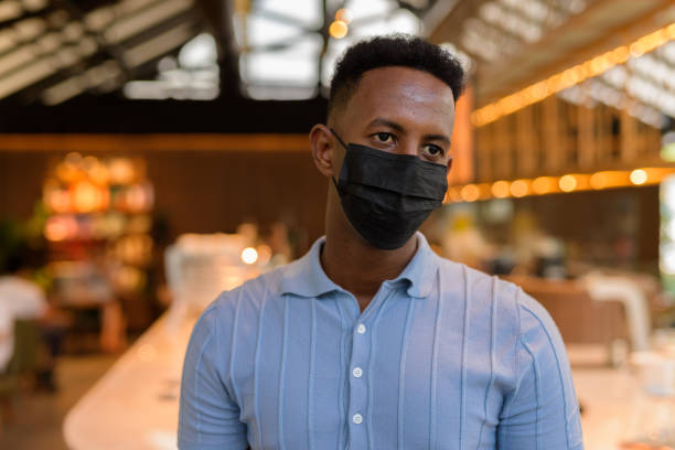 istock African businessman wearing face mask in coffee shop restaurant while thinking 1321646807