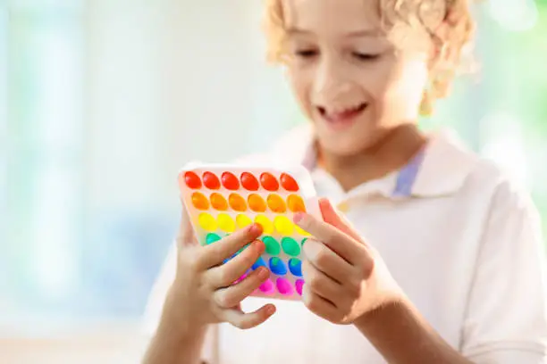 Photo of Kids with pop it sensory toy. Stress relief.