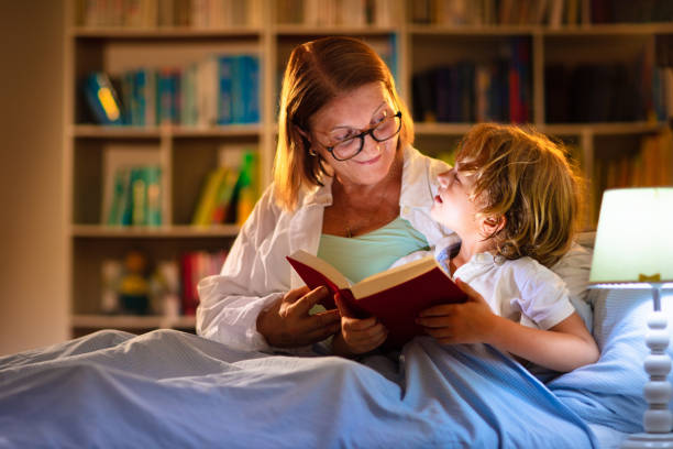 mom and child reading book in bed. kids read. - grandparent reading grandmother child imagens e fotografias de stock