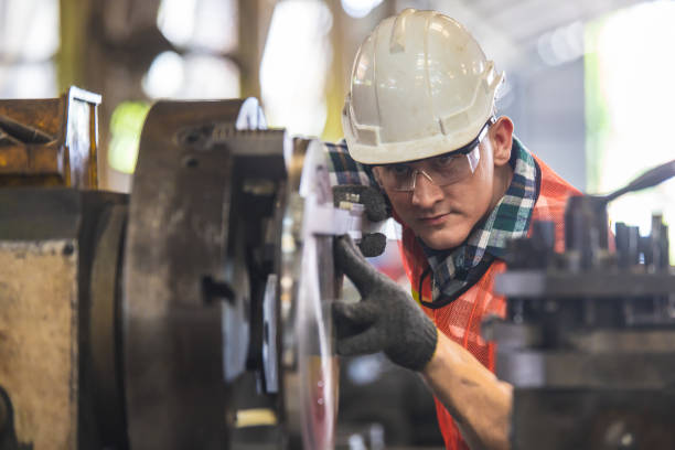 istock worker is working on a lathe machine in a factory. Turner worker manages the metalworking process of mechanical cutting on a lathe 1321650136