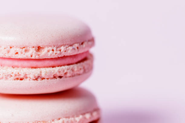 Close-up on nude colored macaroon with rose filling on another macaroon