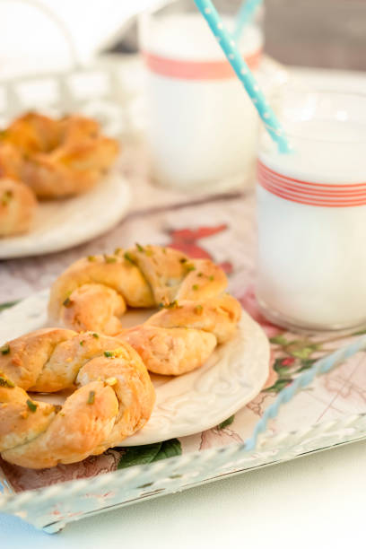 biscuits végétariens avec un verre de lait d’avoine pour le petit déjeuner sans gluten. concept de routine matinale. ombres dures. mise au point sélective. - twisted cheese biscuit pastry photos et images de collection