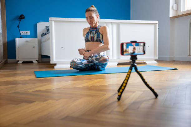 istock Yoga instructor making vlog at home, performing lotus pose 1321650913