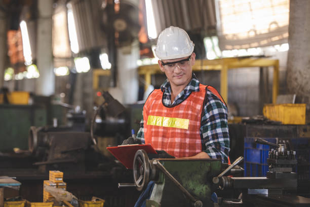 istock engineers in overalls and hardhats holding folder with documents and looking away in the factory 1321651093