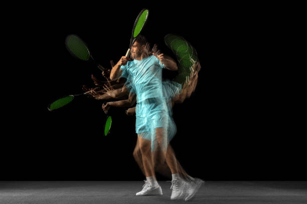 One man, professional tennis player isolated on black background in mixed neon light. Stroboscope In motion. Young Caucasian professional tennis player in blue sports uniform isolated on black backgroundin mixed neon light. Concept of action, speed, energy, sport, competition and ad. temporal aliasing stock pictures, royalty-free photos & images