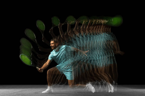 Stroboscope effect. One man, professional tennis player isolated on black background in mixed neon light. Power. Young Caucasian professional tennis player in blue sports uniform training isolated on black backgroundin mixed neon light. Concept of action, speed, energy, sport, competition and ad. temporal aliasing stock pictures, royalty-free photos & images