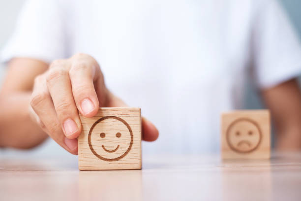 Man hand holding emotion face block. Customer choose Emoticon for user reviews. Service rating, ranking, customer review, satisfaction, evaluation and feedback concept hombre con la mano sosteniendo el bloque de la cara de la emoción. los clientes eligen emoticon para las opiniones de los usuarios. calificación del servicio, clasificación, revisión del cliente, satisfacción, evaluación y concepto de retroalimentaci