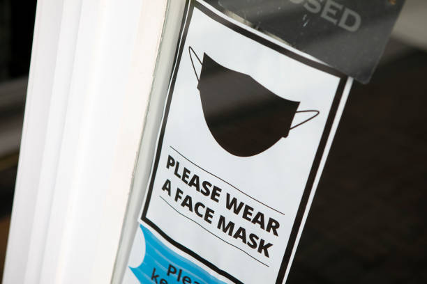 istock 'Please wear a face mask' sign on a store door 1321655119