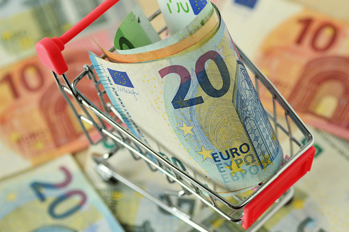 Close-up of shopping cart with euro banknotes - Concept of shopping and economy