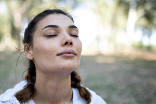 istock woman meditating at green park 1321659791