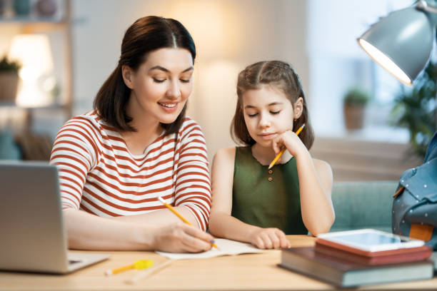 istock Girl doing homework with mother 1321660007