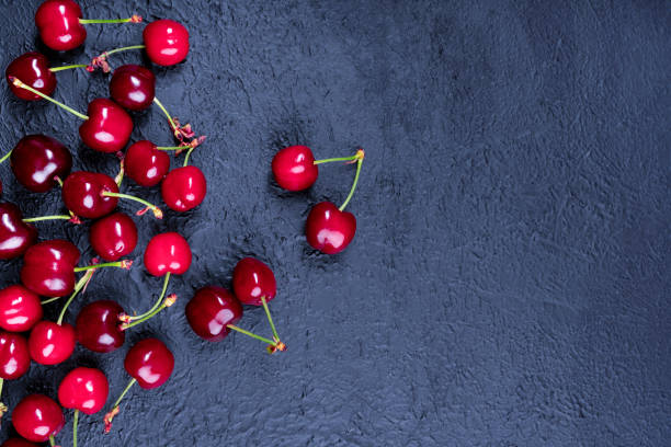 istock Ripe and delicious cherry on black background 1321660800