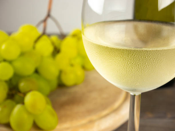 Goblet of white wine. Glass of white wine with bunch of fresh grapes. stock photo