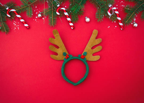 istock Red flat lay minimalistic background with Christmas tree and antler deer mask. Top view, copy space, place for text 1321661230