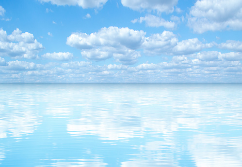 blue sky and white clouds reflected in seawater.