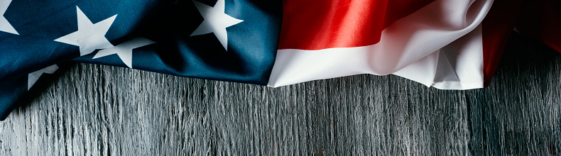 a flag of the united states of america on a gray wooden background, in a panoramic format to use as web banner or header