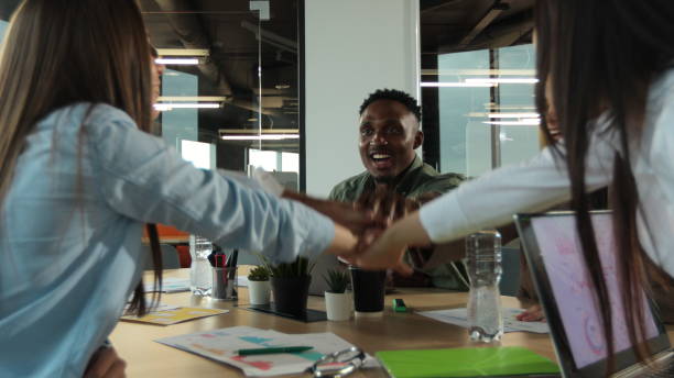 istock Office workers doing team building exercise stacking hands together in the unifying spirit of creativity and common cause. 1321664622