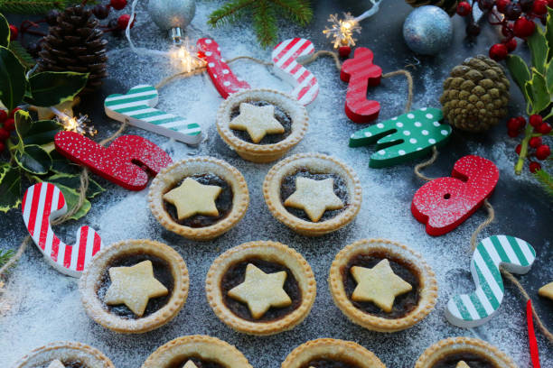 istock Image mince pies laid out like Christmas tree surrounded by decorations spelling out Christmas, festive dessert, crispy pastry with sweet mincemeat (mixture chopped dried fruit, distilled spirits, spices), star shaped pastry top sprinkled with icing sugar 1321664682