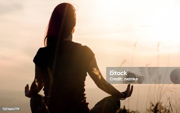 Silhouette Of Young Woman Practicing Yoga Outdoors Stock Photo - Download Image Now - Meditating, Zen-like, Yoga