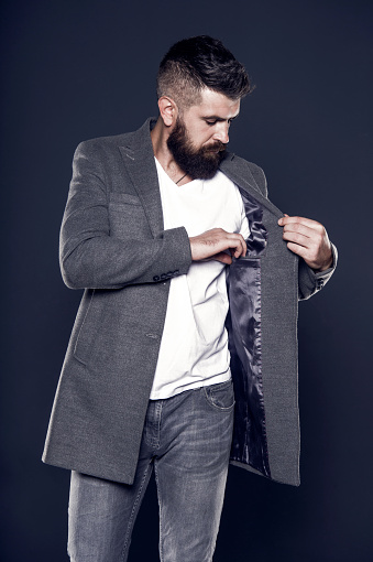 Pocket inside coat. Serious concentrated man. Caucasian man with brutal appearance. Bearded man with moustache and beard on unshaven face in brutal style. Brutal hipster wearing casual outfit.