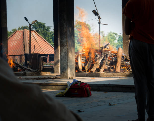 un colpo di pira che bruciava durante una cremazione lungo il fiume laterale ad haridwar, in india. - death toll foto e immagini stock