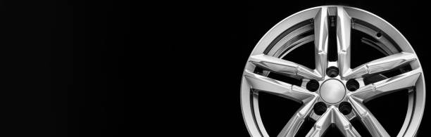 istock silver alloy wheel with bifurcated beams on a black background, copy space, long panoramic 1321669068