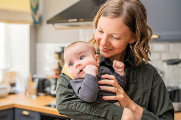 istock mom with baby in her arms in the kitchen kitchen 1321676096