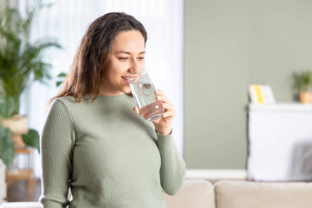 istock Young woman drinking water and smiling 1321676928