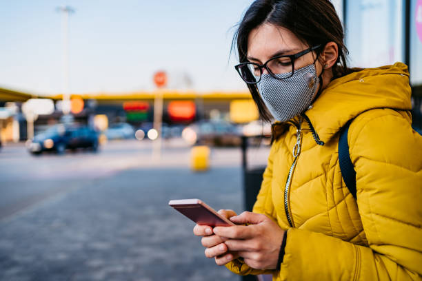 istock Woman in shopping mall with face mask using phone 1321682183