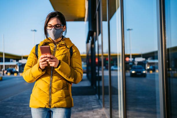 istock Woman in shopping mall with face mask using phone 1321682480