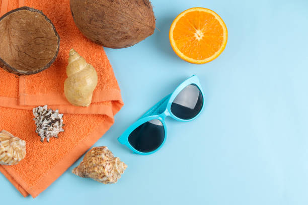 istock summer accessories with coconut, orange, sun glasses and shells, on a bright blue background. free space. top view. frame 1321684201