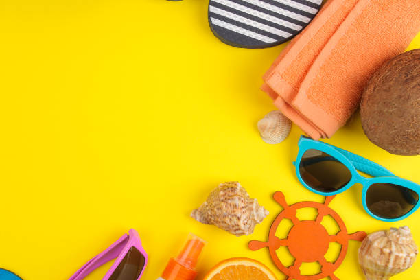 istock summer accessories with shells, sun glasses, orange and coconut on a bright yellow background. top view. space for text 1321684213