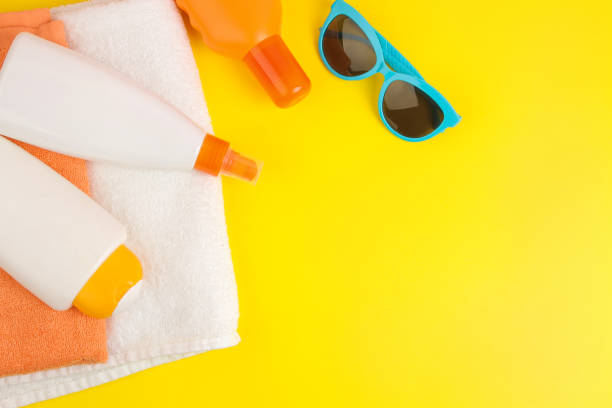 istock summer accessories. beach accessories. sunscreen and towels on a bright yellow background. top view. space for text 1321684221