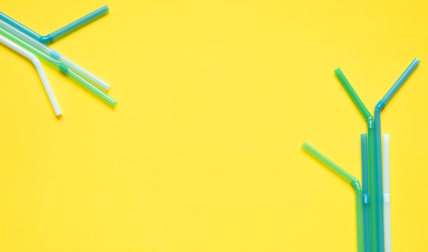 plastic drinks tubes on a yellow background with space for text - drinking straw plastic design in a row imagens e fotografias de stock