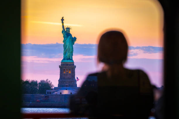 donna guarda la statua della libertà - freedom sunset landscape travel foto e immagini stock