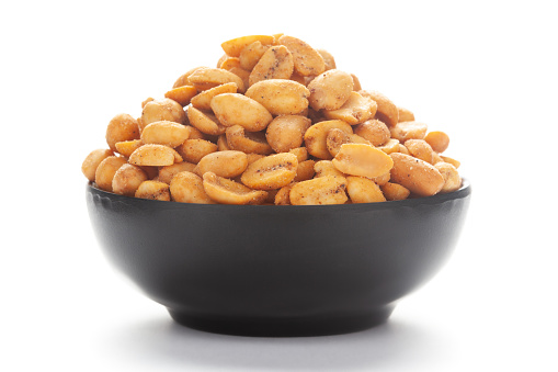 Close up of Crunchy masala peanuts Indian namkeen (snacks) on a ceramic black bowl.
