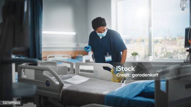 Hospital Ward Professional Black Nurse Wearing Face Mask Wiping The Bed Cleaning Room After Covid19 Patients Recover Disinfection Sterilizing Sanitizing Clinic After Coronavirus Infected People Stock Photo - Download Image Now