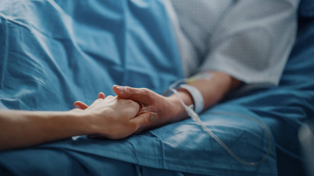 salle d’hôpital: femme âgée se reposant dans un lit avec un moniteur de fréquence cardiaque des doigts, un membre de la famille attentionné tient sa main fragile, soutien et réconfortant. concentrez-vous sur les mains. - senior adult child holding grandparent photos et images de collection