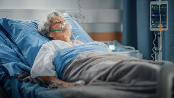 hospital ward: portrait of beautiful elderly woman wearing oxygen mask sleeping in bed, fully recovering after sickness. old lady dreaming of her family, friends, happy life. - oxygen imagens e fotografias de stock