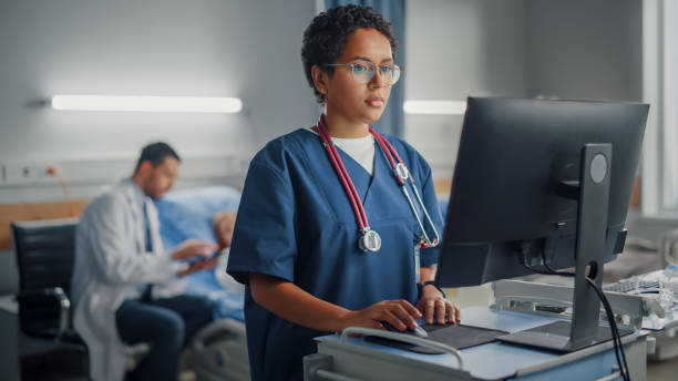 병원 병동: 전문 미소 흑인 여성 머리 간호사 또는 청진기를 착용 하는 의사 의료 컴퓨터를 사용 하 여. 병과 수술 후 성공적으로 회복 침대에서 배경 환자 - 간호사 뉴스 사진 이미지