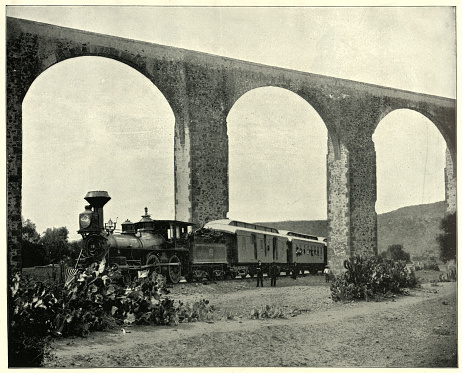Vintage photograph of Steam train in front of the Aqueduct at Queretaro, Mexico, an 18th-century aqueduct in the Mexican city of Querétaro.
