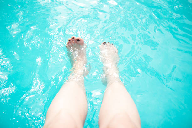 istock Female legs in the pool. Summer vacation 1321697338
