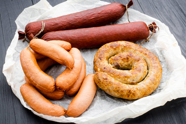 istock Different types of natural sausages on a wooden background. 1321699162