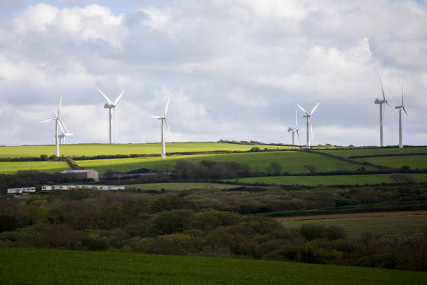 istock Wind turbines in green fields, with a cloudy sky, viewed in sunlight 1321699535