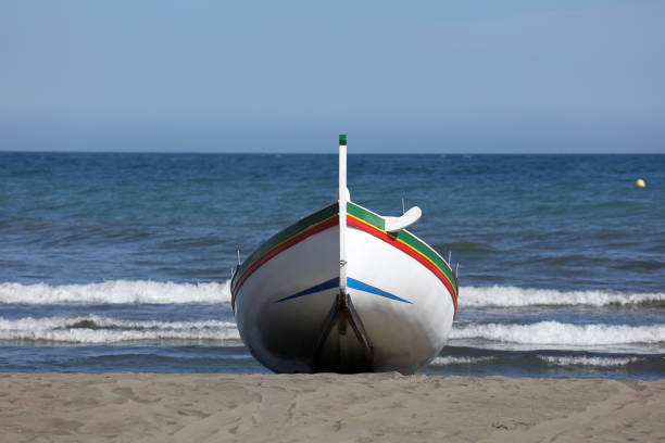 istock fishing boat on the beach, with blue sky 1321700519